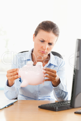 Businesswoman with an empty piggy bank