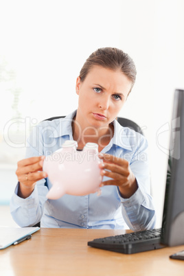 Sad businesswoman with an empty piggy bank