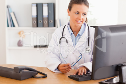 Serious female doctor working with a computer