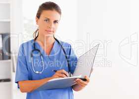 Doctor holding an open folder and having a stethoscope around he