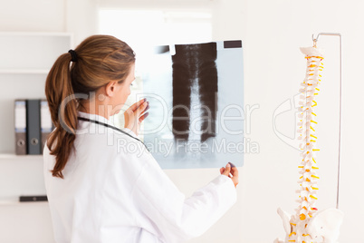 Gorgeous doctor with a stethoscope looking at a x-ray