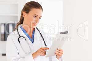 Charming doctor having a stethoscope around her neck looking at