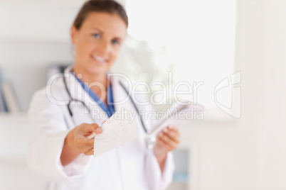 Smiling doctor handing out a prescription