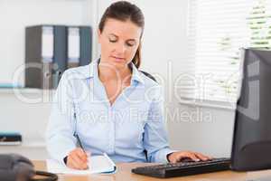 Concentrated businesswoman writing something down