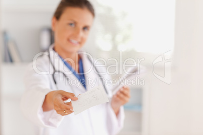 Brunette doctor handing out a prescription