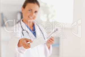 Brunette doctor handing out a prescription