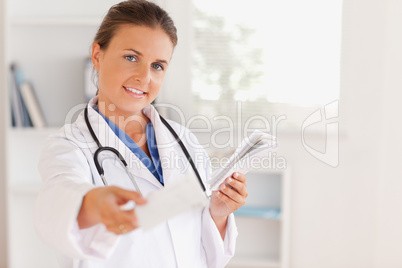 Charming brunette doctor handing out a prescription Charming brunette doctor handing out a prescription