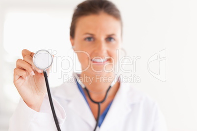 gorgeous doctor showing stethoscope to the camera