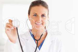 gorgeous brunette doctor showing stethoscope looking into the ca