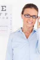 Portrait of a brunette eye specialist wearing glasses looking in