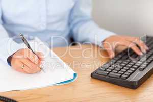 gorgeous businesswoman typing and writing