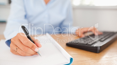 gorgeous brunette businesswoman typing and writing