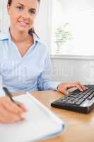 Brunette working businesswoman sitting behind her desk looking i