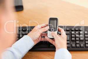 Woman holding cellphone against keyboard