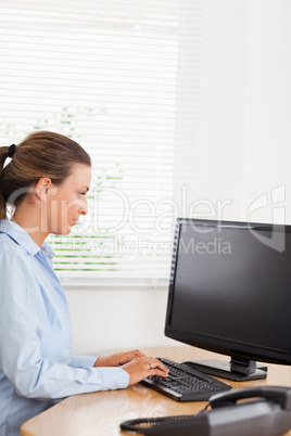 Woman typing and looking to screen