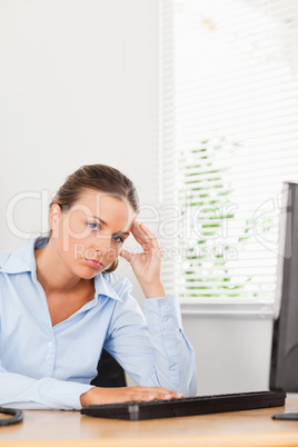 Businesswoman holding her head in office