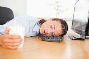Sleeiping woman in an office holding coffee
