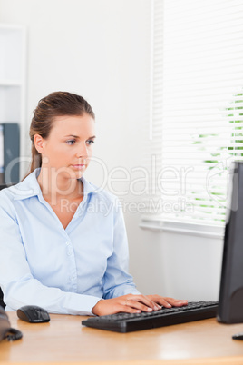 Secretary typing on keyboard in office