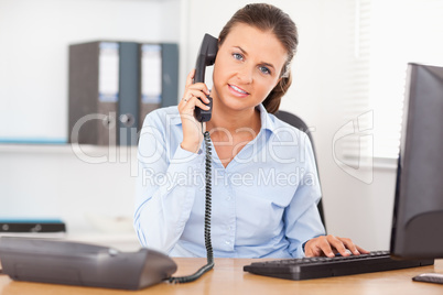 Telephoning businesswoman in office