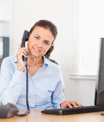 Telephoning businesswoman in an office