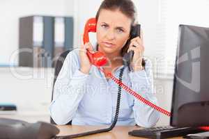 Secretary telephoning with two telephones