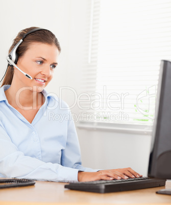 An operator with headset is typing in an office