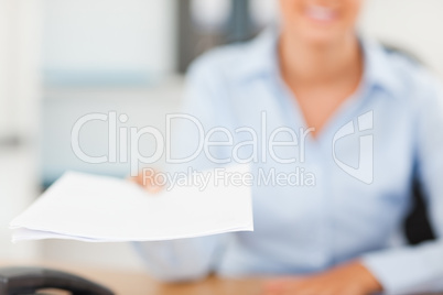Smiling businesswoman handing out a paper