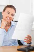 Charming businesswoman smiling at a paper