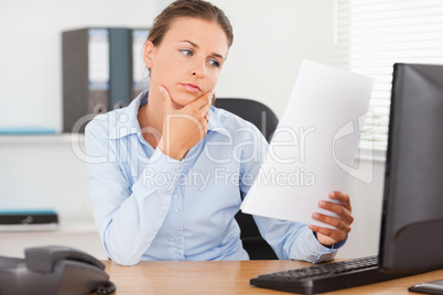 Charming businesswoman concentrating on a paper