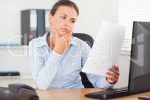 Charming businesswoman concentrating on a paper
