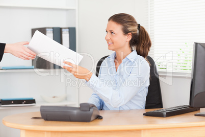 smiling businesswoman receiving a pile of paper