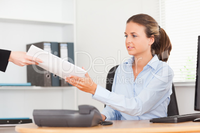 stressed businesswoman receiving a pile of paper