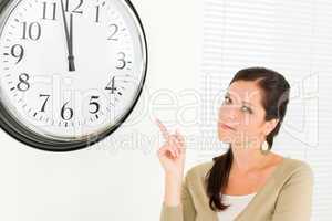 Punctual businesswoman attractive point at clock