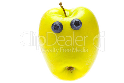 green apple with eyes of blueberries isolated on white