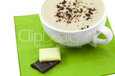 cup of cappuccino, chocolate and flower on a napkin
