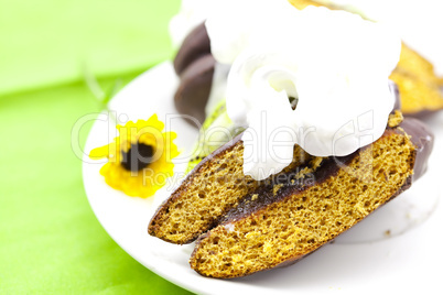 cake with cream and a flower on a green background