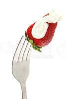 strawberries and cream on fork isolated on white