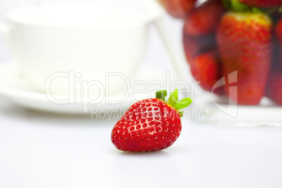 cup and strawberry in a glass bowl isolated on white