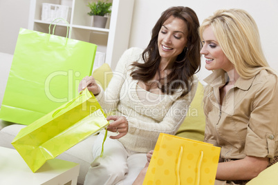 Two Beautiful Women Friends Looking in Shopping Bags at Home