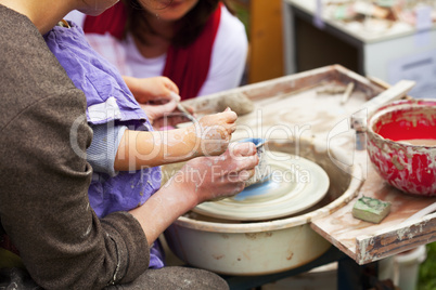 woman and child in a potter's wheel