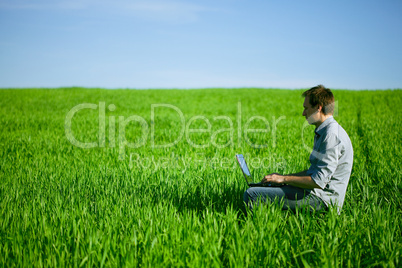 Young man using a laptop outdoors