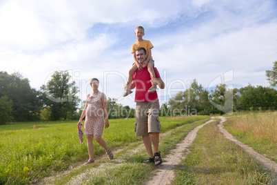 Happy family with pregnant woman, kid and father