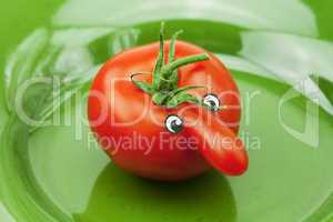 tomato with a nose lying on the green dish