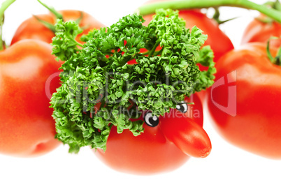 tomato with a nose and green isolated on white