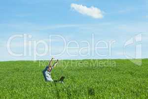 young man uses a laptop in the green field