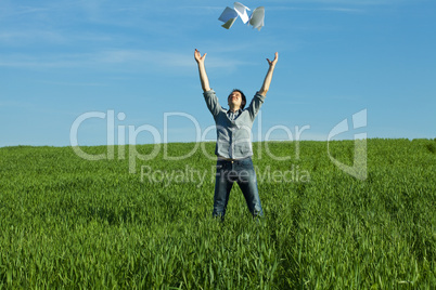 young man throwing a paper in the green field