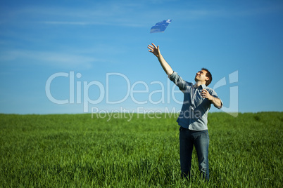 young man throwing a paper in the green field