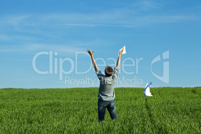 young man throwing a paper in the green field