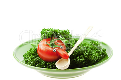 tomato  with the nose on a green plate isolated on white