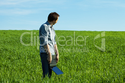 young man using laptop in the field